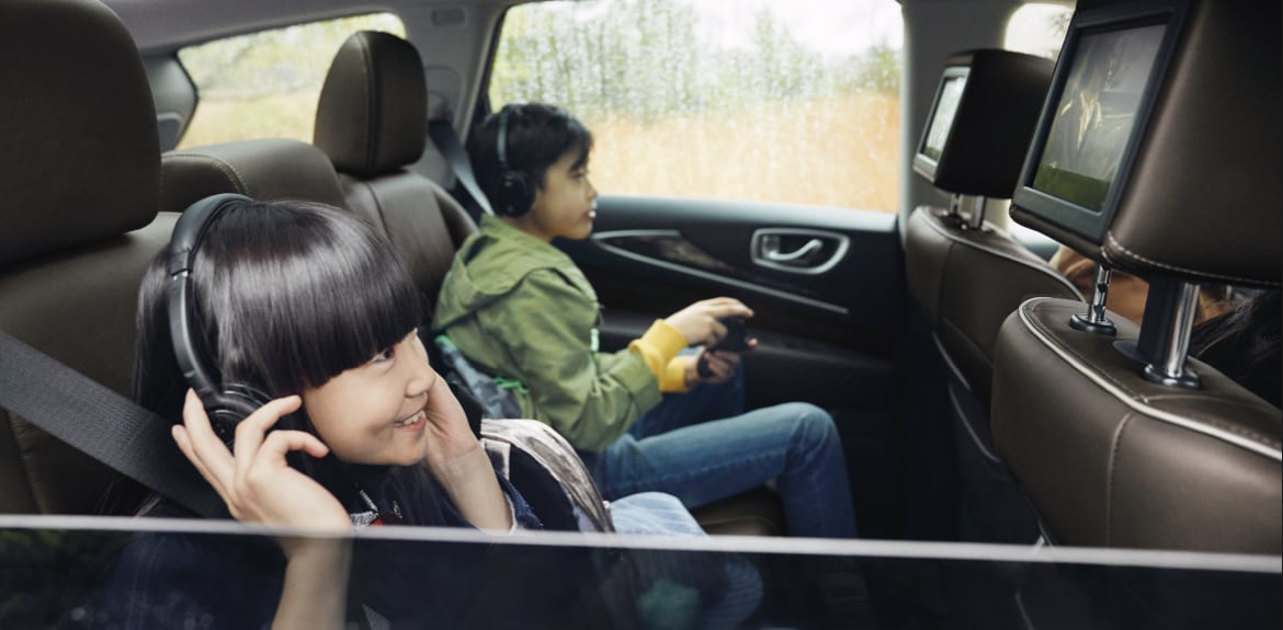 Kids sitting safely in the second row seats in an INFINITI SUV