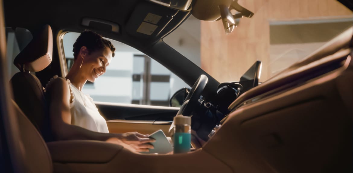 Woman smiling and connecting her phone to the INFINITI QX80 SUV